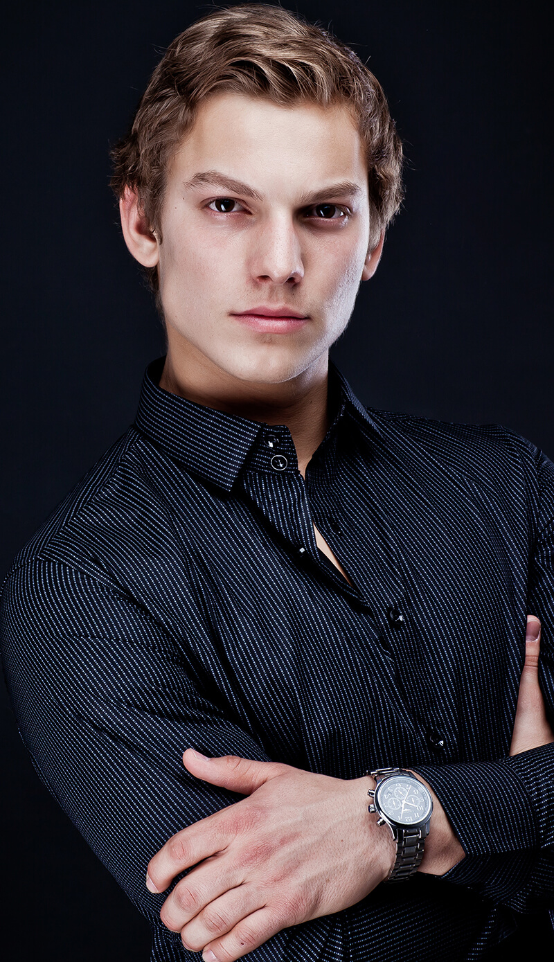 A man in a black shirt poses for a photo