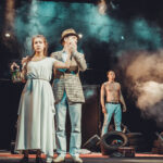 Two men and a woman on the stage of the theater